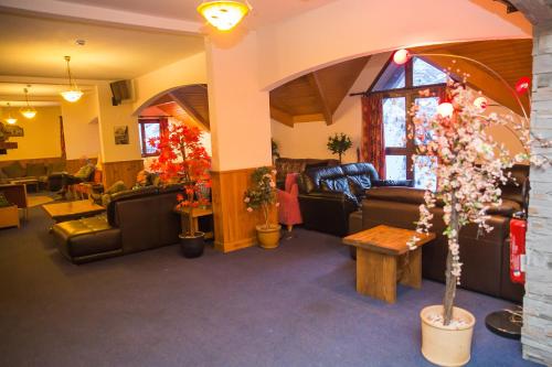 a living room with couches and chairs and a tree at Hotel l'Aigle in Valmeinier