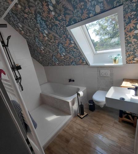 a bathroom with a sink and a toilet and a window at Ferienwohnung Margarethe in Stedesdorf