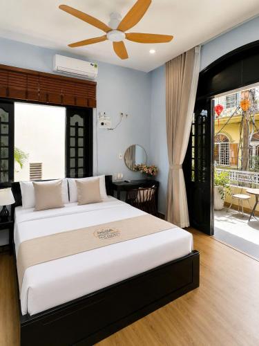 a bedroom with a large bed with a ceiling fan at Hue Ancient Hostel in Hue
