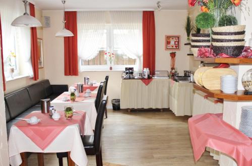 a restaurant with two tables with pink tablecloths at Arador-City Hotel in Bad Oeynhausen
