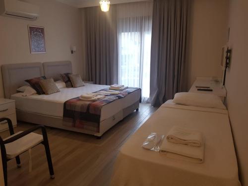 a bedroom with two beds and a table and a window at Süreyya Hanım Otel in İzmir