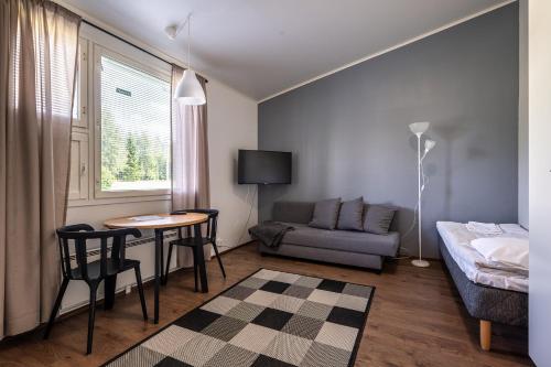 a small living room with a table and a couch at LODGE Hostel Kuusamo in Kuusamo
