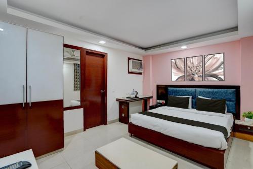 a bedroom with a king sized bed and pink walls at Townhouse Millenium City Centre in Gurgaon