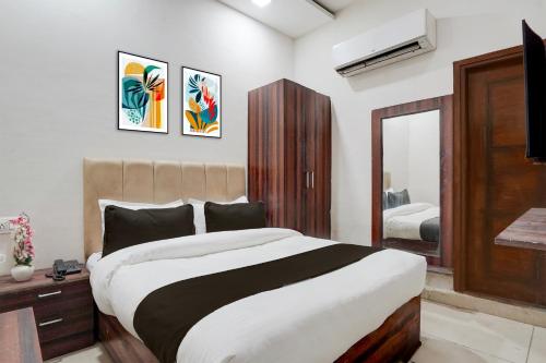 a bedroom with a large bed and a mirror at Super Collection O by OYO Patiala Road Crossway Zirakpur Formerly Lavish in Zirakpur