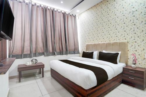 a bedroom with a large bed and a television at Super Collection O by OYO Patiala Road Crossway Zirakpur Formerly Lavish in Zirakpur