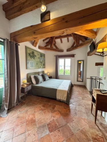a bedroom with a bed in a room with wooden ceilings at Cuq en Terrasses in Cuq-Toulza
