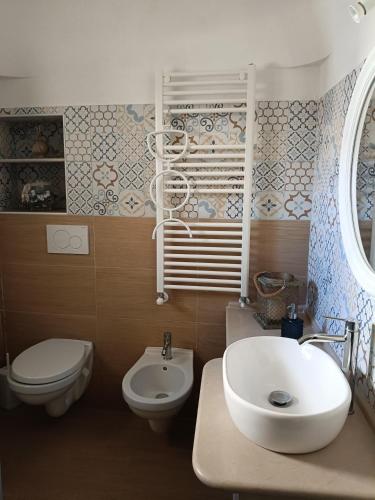 a bathroom with a sink and a toilet at Trullo Le Tre Sorelle in Cisternino