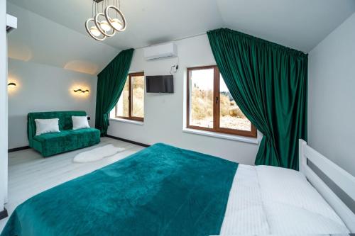 a bedroom with a green bed and a couch at Alpine in Skhidnitsa