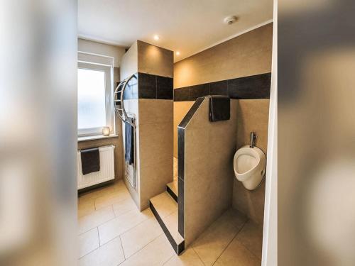 a bathroom with a urinal on the wall at Apartment Wohnung „Sonnendeck“ by Interhome in Laupheim