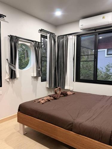 a bedroom with a large bed in front of windows at C S phangan Villa in Ban Madua Wan