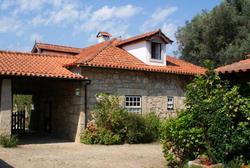 a stone house with an orange tiled roof at Casa da Roseira in Ponte de Lima