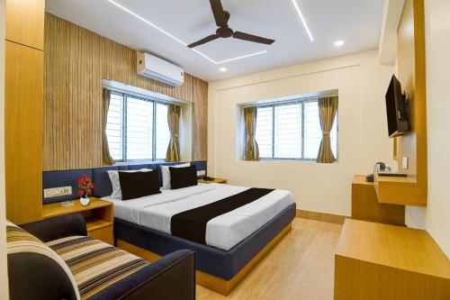 a hotel room with a bed and a couch at Super Collection O Newtown Bus Stand Formerly The Executive Suites in New Town