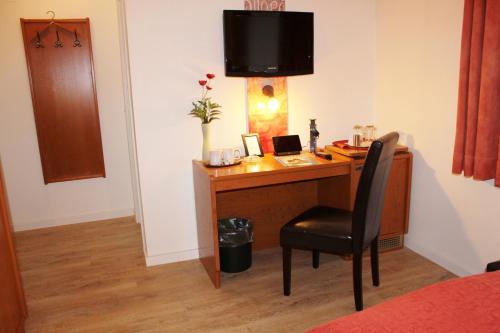 a desk with a chair in a room at Arador-City Hotel in Bad Oeynhausen
