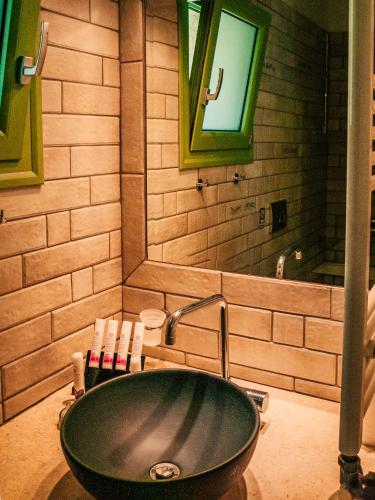 a bathroom with a black sink and a mirror at Petra & Thalassa in Plataria