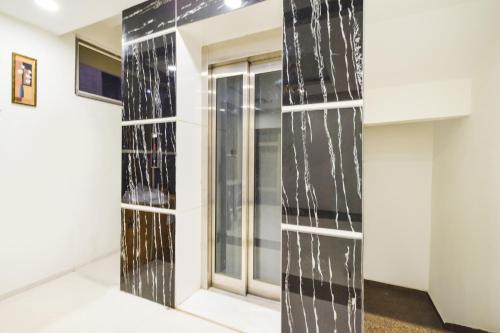 a room with black and white tile on the wall at Super Townhouse Raniganj Formerly Devi Residency in Hyderabad
