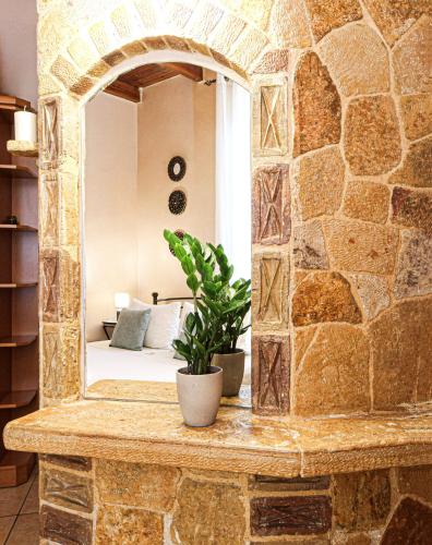 a mirror on a stone wall in a bedroom at Villa Anthemida Chania in Ayiá