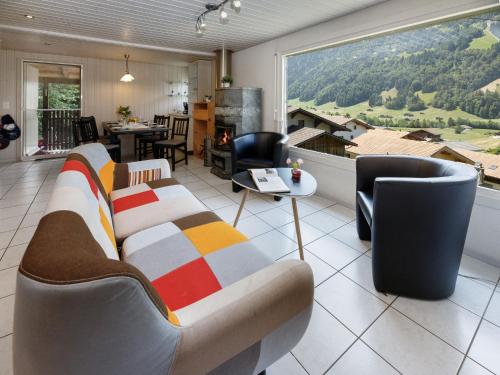 a living room with a couch and a large window at Holiday Home Chalet Guldeli by Interhome in Kandergrund