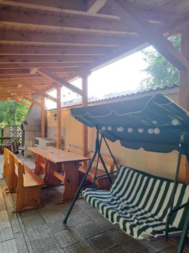 a patio with a table and a bench and an umbrella at Casa Bianca - Summer residency in Primorsko