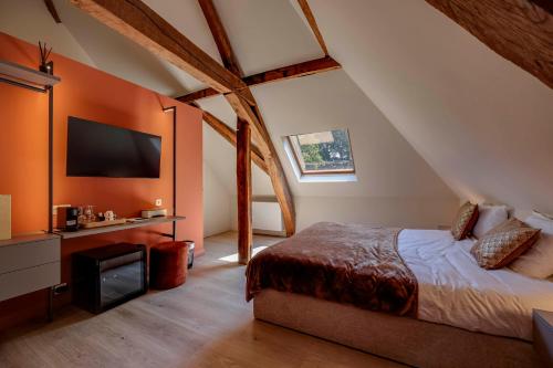 a bedroom with a bed and a flat screen tv at Boutique hotel Roosendaelhof in Geel