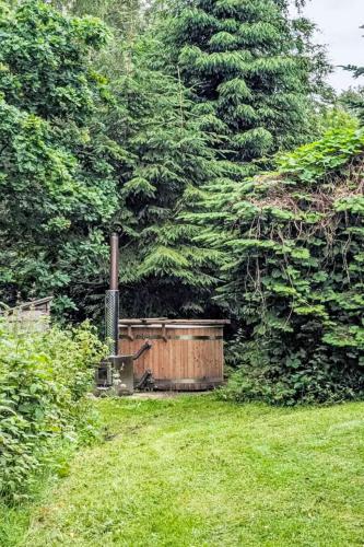a wooden hot tub in a yard with trees at Chalet Rowan Cottage by Interhome in Inverness