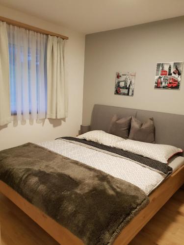 a large bed in a bedroom with a window at Ferienwohnung Unterlechner - Apt 3 in Vomp