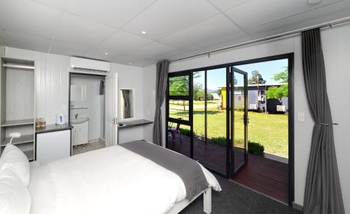 a bedroom with a bed and a large sliding glass door at SleepOver Phabeni in Hazyview