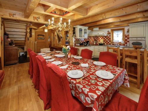 a dining room with a table and red chairs at Chalet Dörfli by Interhome in Les Diablerets