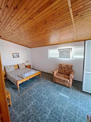a bedroom with a bed and a chair in it at Casa Bianca - Summer residency in Primorsko