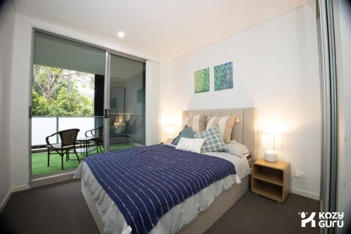 a bedroom with a bed and a sliding glass door at KozyGuru | Epping | Stylish 1 Bedroom Apartment in Epping