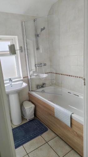 a bathroom with a bath tub and a sink at 15 Aller Park Rd, Newton Abbot in Newton Abbot
