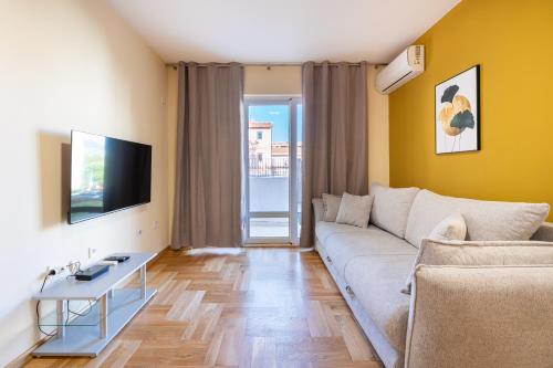a living room with a couch and a tv at Apartments Bečić in Budva