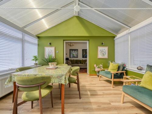 a dining room with a table and green chairs at Holiday Home Sullivan by Interhome in Drumnadrochit