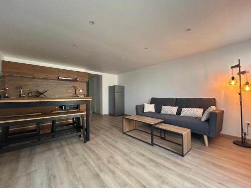 a living room with a couch and a table at Maison indépendante Anna in Wittenheim