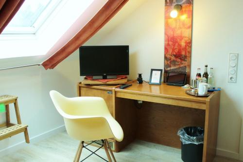 a desk with a computer and a chair in a room at Arador-City Hotel in Bad Oeynhausen