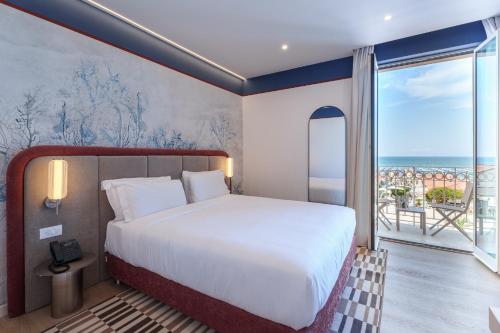 a bedroom with a bed and a view of the ocean at Vi Place in Lido di Camaiore