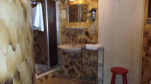 łazienka z umywalką, lustrem i stołkiem w obiekcie Landhaus Krinnenspitze w mieście Nesselwängle