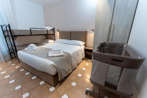 a bedroom with a bed and a chair with towels at Hotel Villa Itala in Rimini
