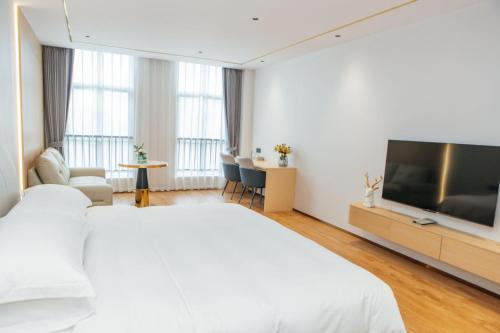 a hotel room with a bed and a flat screen tv at 玉恒酒店 in Sihui