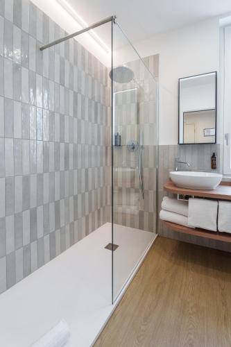a bathroom with a glass shower and a sink at Vi Place in Lido di Camaiore