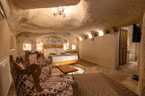 a bedroom with a bed and a couch and a table at Aren Cave Hotel And Art Gallery in Göreme