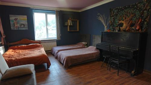 a bedroom with two beds and a piano at The Kalavan Retreat Center in Chambarak