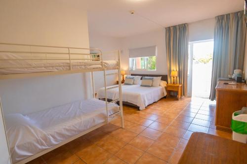 a bedroom with two bunk beds and a living room at Centre Algarve in Moncarapacho