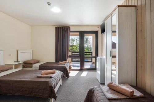 a hotel room with two beds and a balcony at Kredo in Solotvyno