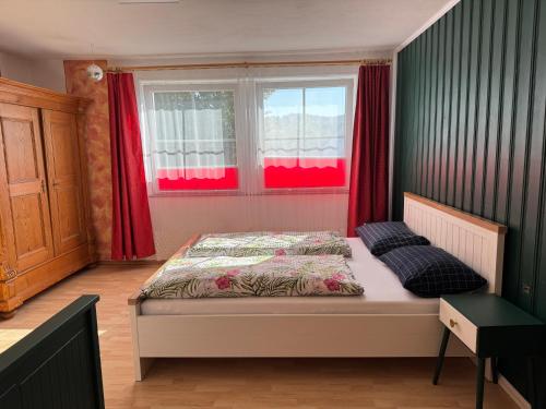 a bedroom with a bed and a window with red curtains at Apartment Florence in Wettringen