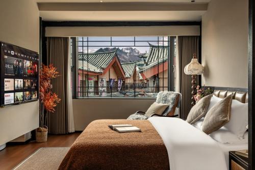 a bedroom with a bed and a large window at Yunman Sky Cloud Quiet Garden Guesthouse offers breakfast and afternoon tea with free airport shuttle services The hotel provides a platform for visiting the ancient city and Yulong snow in Lijiang