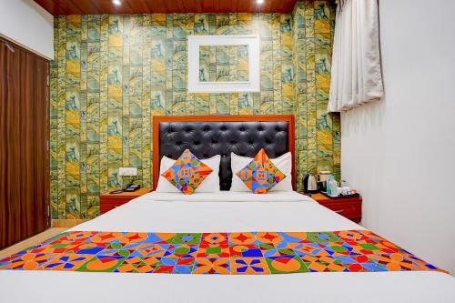 a bedroom with a large bed with a colorful comforter at FabHotel SV Grand I in Varanasi