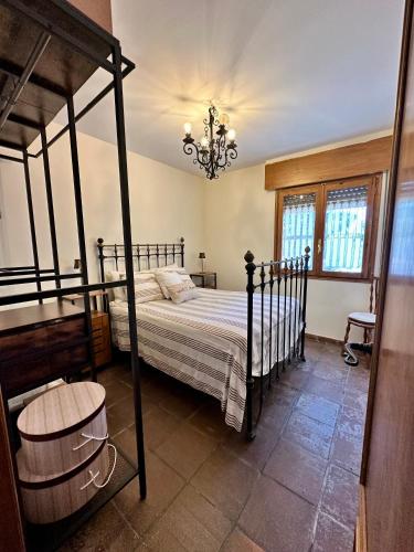 a bedroom with a bed and a chandelier at Finca Viña Alberto in Cuéllar