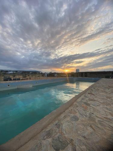 a large swimming pool with a sunset in the background at Samburu Tempo Camp in Archers Post