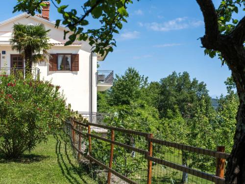 a house with a fence and a tree at Holiday Home Orbani by Interhome in Lovran