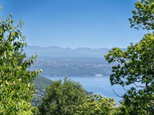 a view of a lake from between two trees at Holiday Home Orbani by Interhome in Lovran